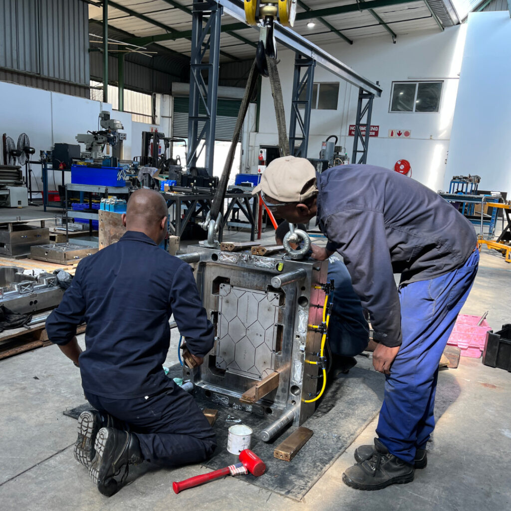 Employees in toolroom working on machinery